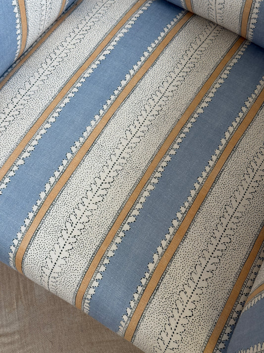 Refurbished antique armchair upholstered in Linwood Dimity ‘Powder Blue’, with a high back, side wings, dark wooden legs and brass casters.