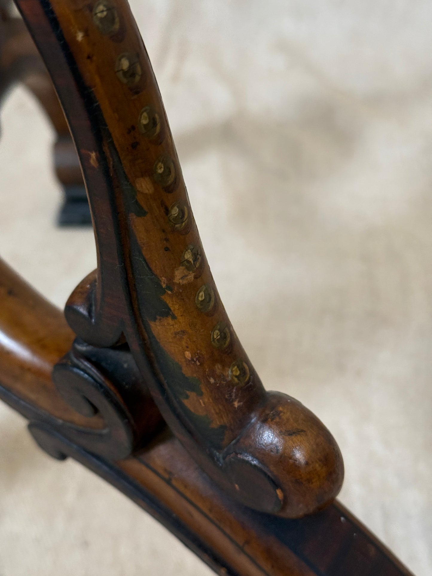 Two ornate dark brown Torchere Stands with decorative scrollwork bases, shown against a draped beige fabric backdrop. 