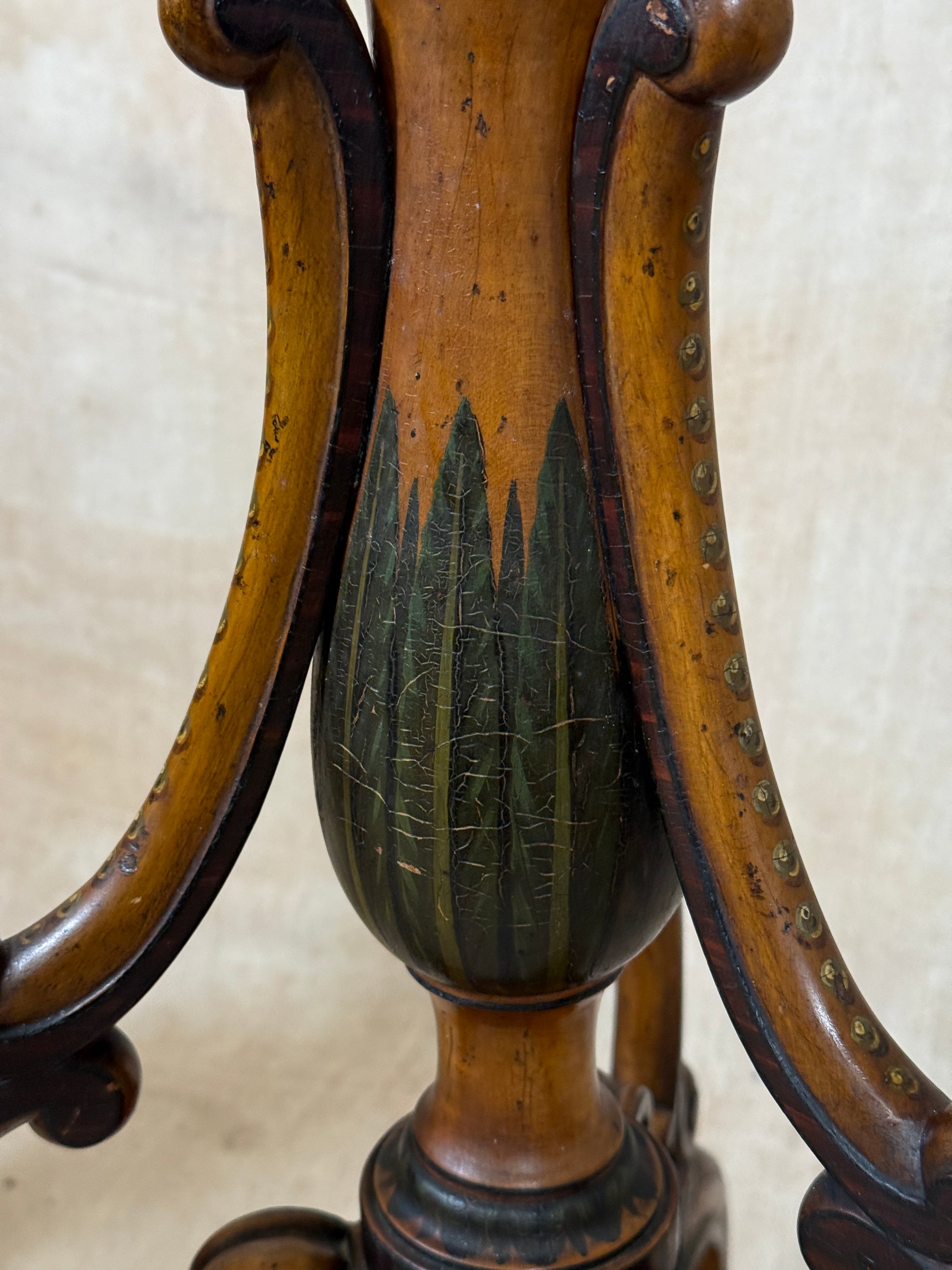 Two ornate dark brown Torchere Stands with decorative scrollwork bases, shown against a draped beige fabric backdrop. 