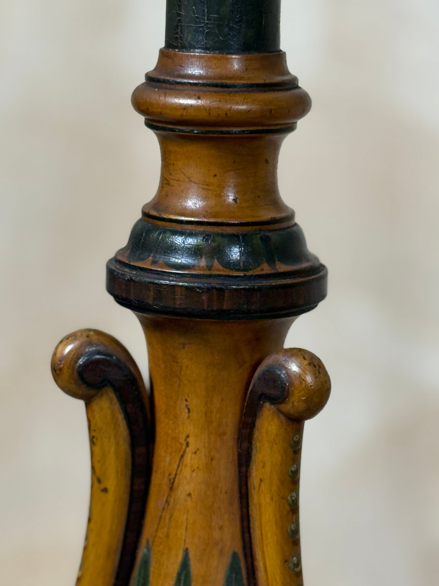 Two ornate dark brown Torchere Stands with decorative scrollwork bases, shown against a draped beige fabric backdrop. 
