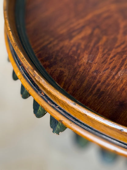 Two ornate dark brown Torchere Stands with decorative scrollwork bases, shown against a draped beige fabric backdrop. 
