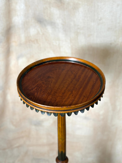 Two ornate dark brown Torchere Stands with decorative scrollwork bases, shown against a draped beige fabric backdrop. 