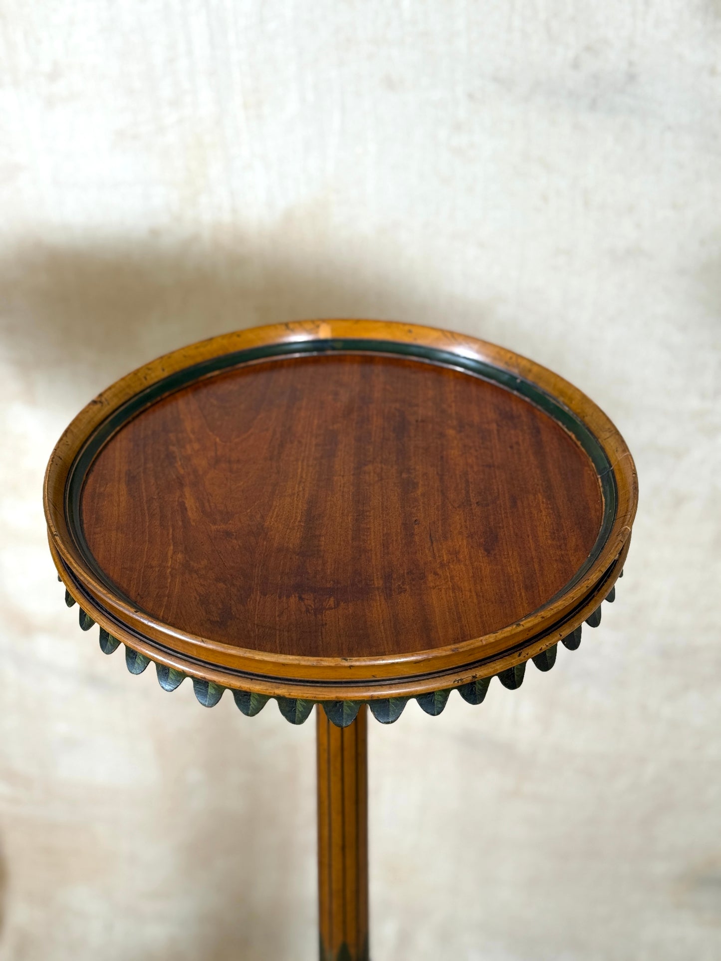 Two ornate dark brown Torchere Stands with decorative scrollwork bases, shown against a draped beige fabric backdrop. 
