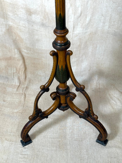 Two ornate dark brown Torchere Stands with decorative scrollwork bases, shown against a draped beige fabric backdrop. 