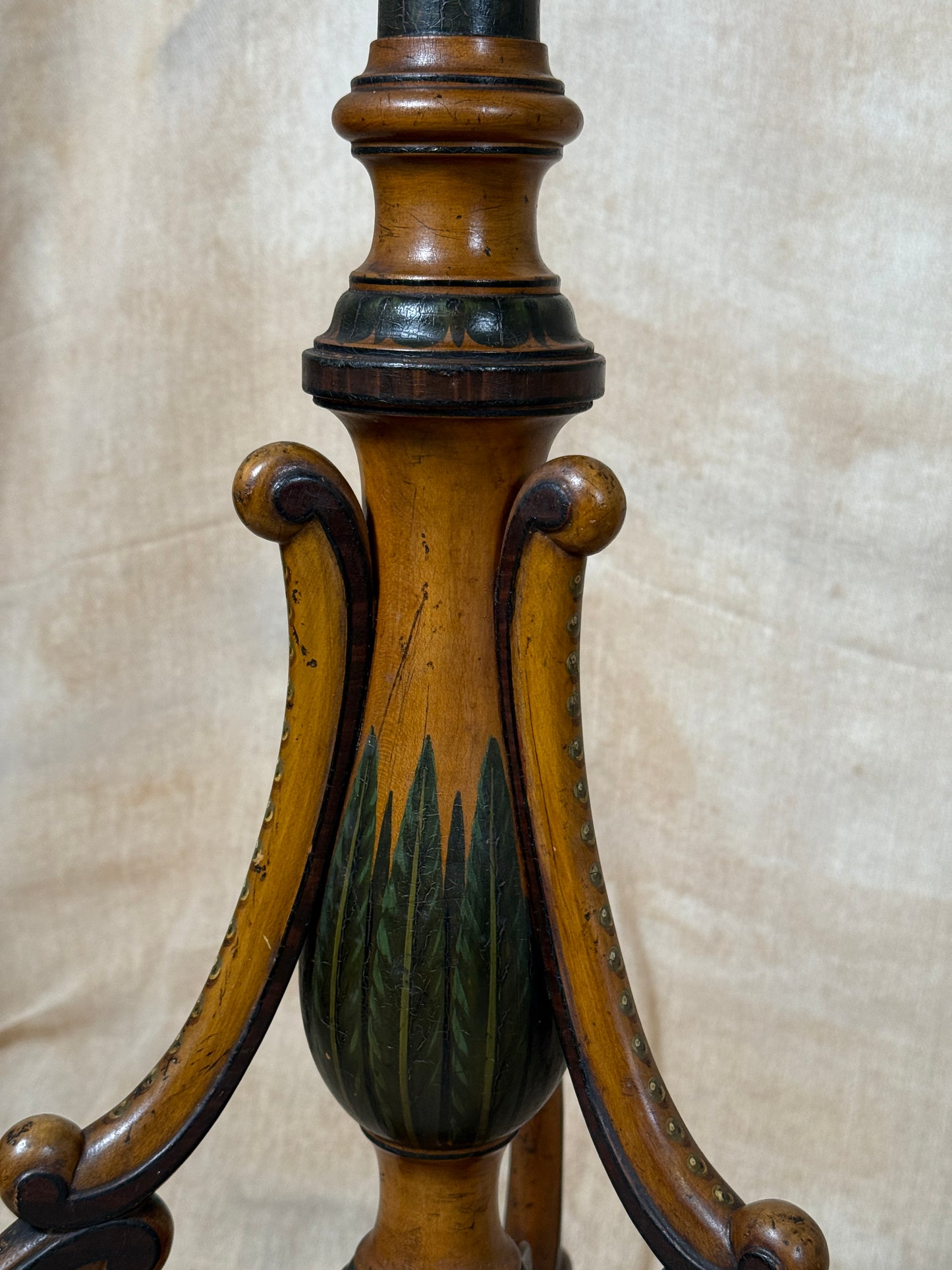 Two ornate dark brown Torchere Stands with decorative scrollwork bases, shown against a draped beige fabric backdrop. 