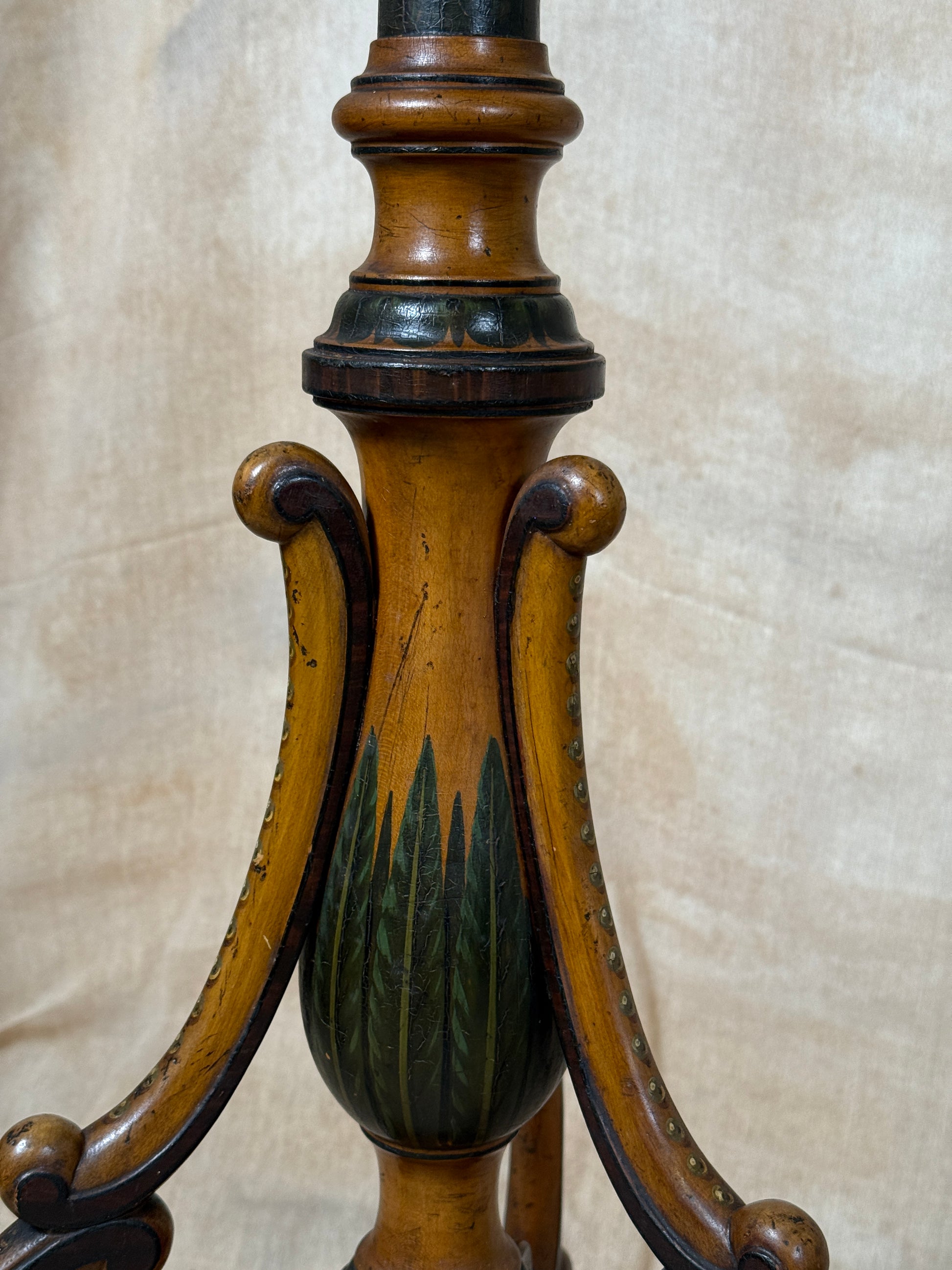 Two ornate dark brown Torchere Stands with decorative scrollwork bases, shown against a draped beige fabric backdrop. 