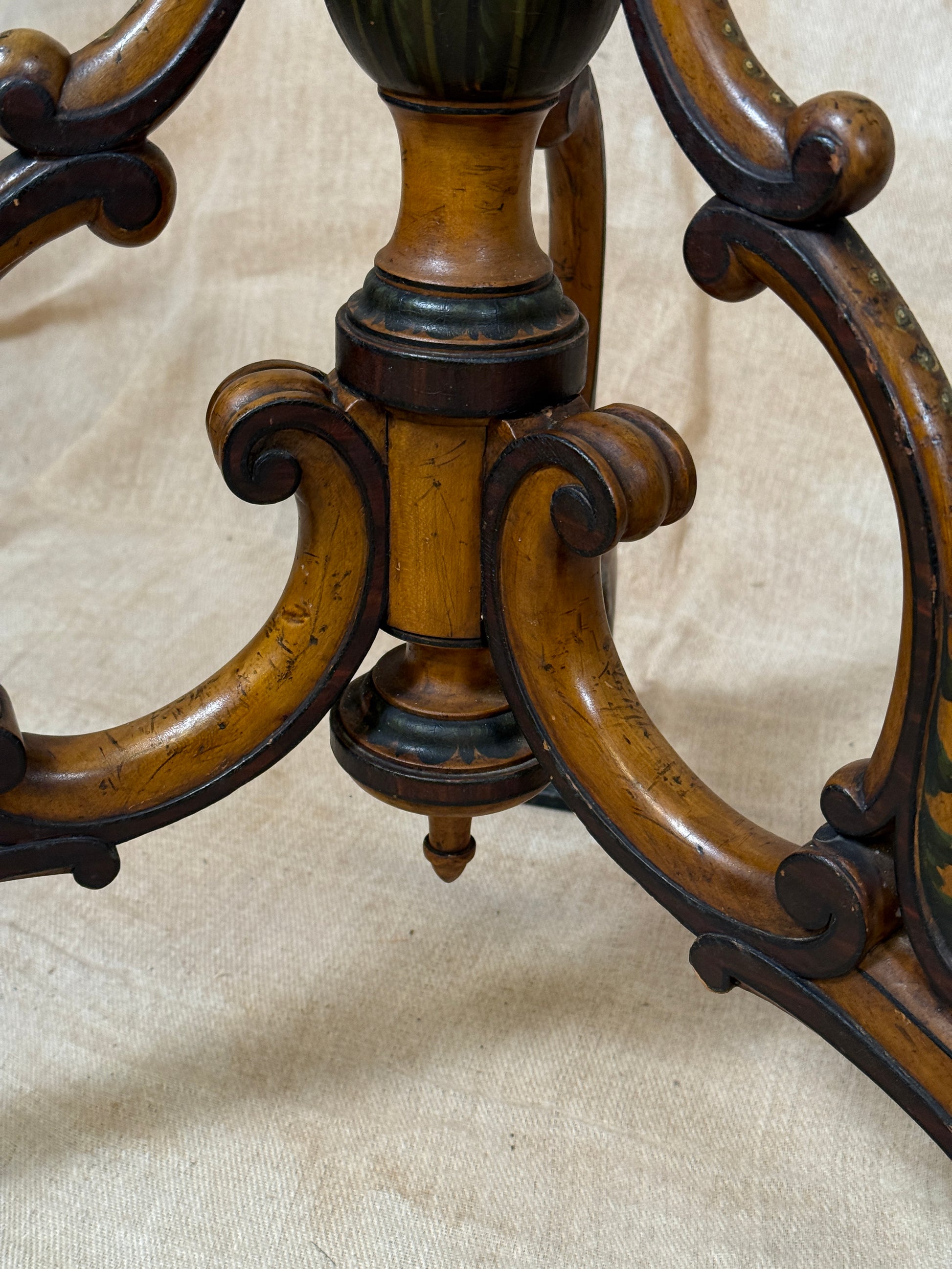 Two ornate dark brown Torchere Stands with decorative scrollwork bases, shown against a draped beige fabric backdrop. 