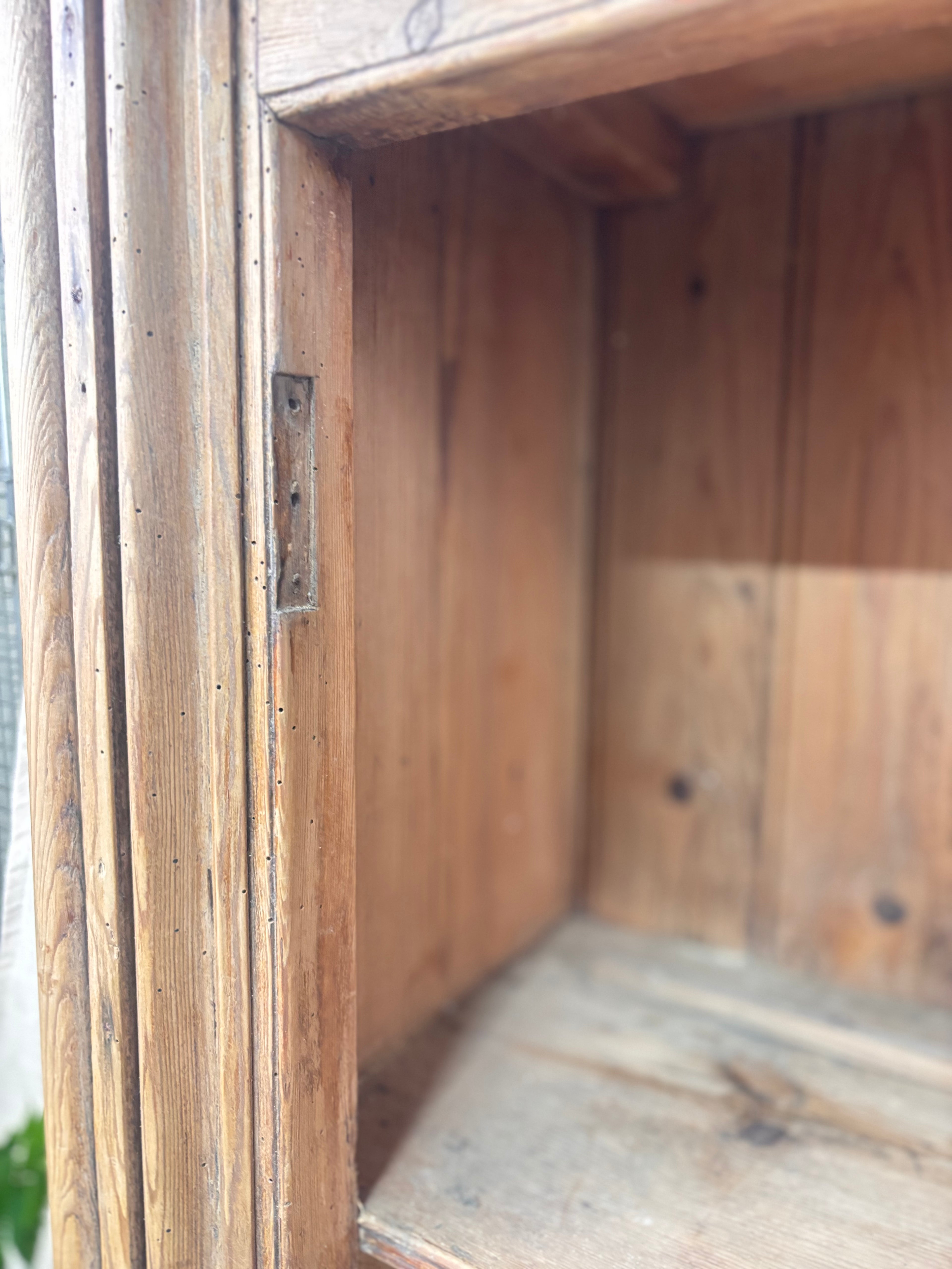 Close-up of a wooden cabinet with a focus on the corner and hinge.