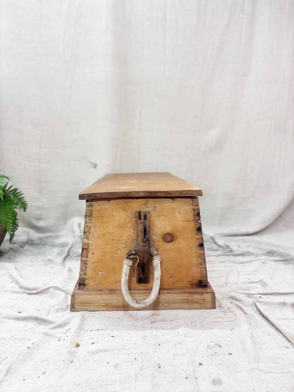 Wooden box with a handle on a white fabric background