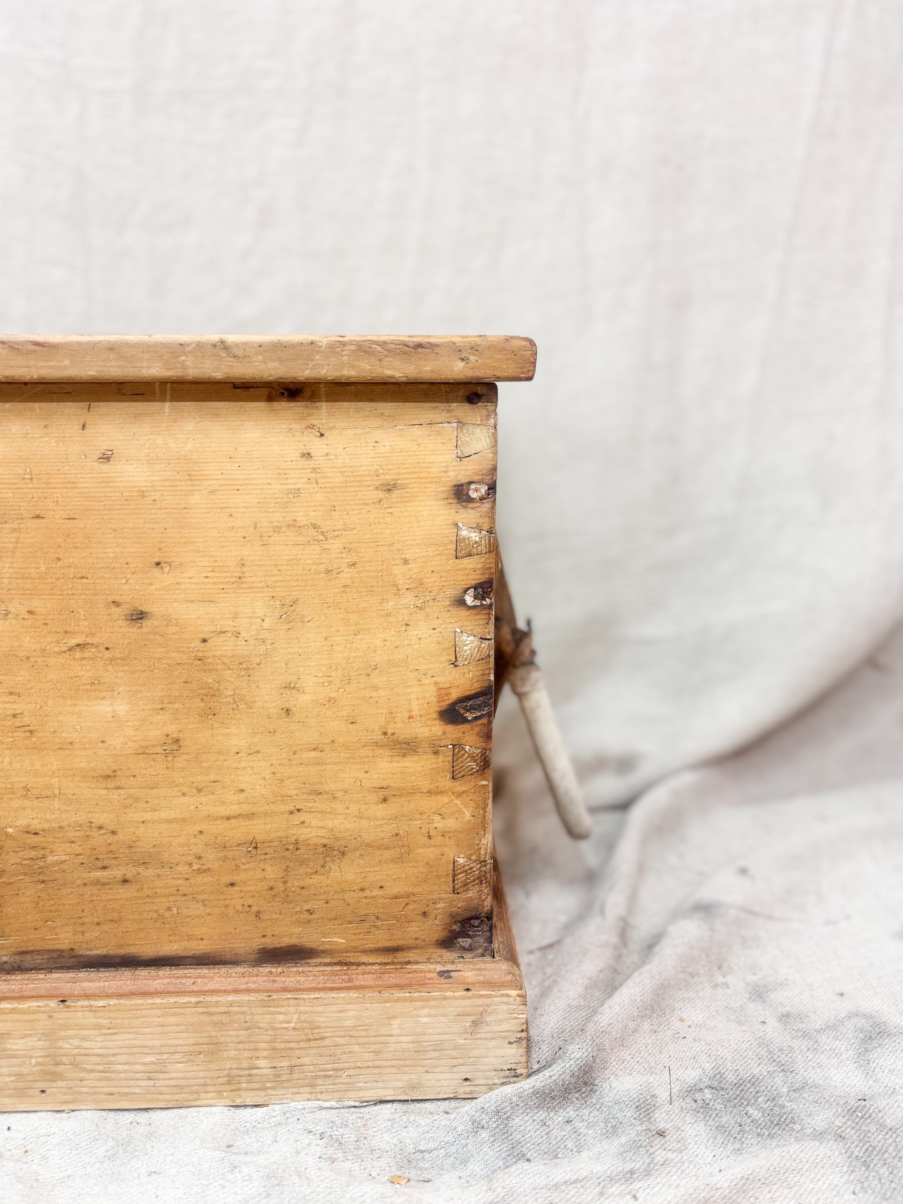 Close-up of a wooden box with a textured surface on a light background