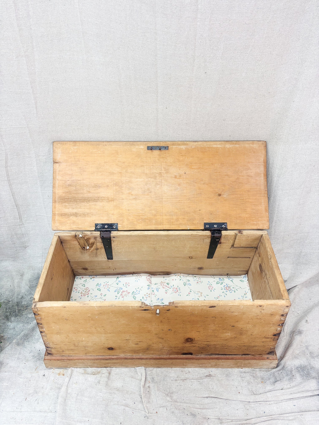 Wooden trunk with a hinged lid on a textured surface