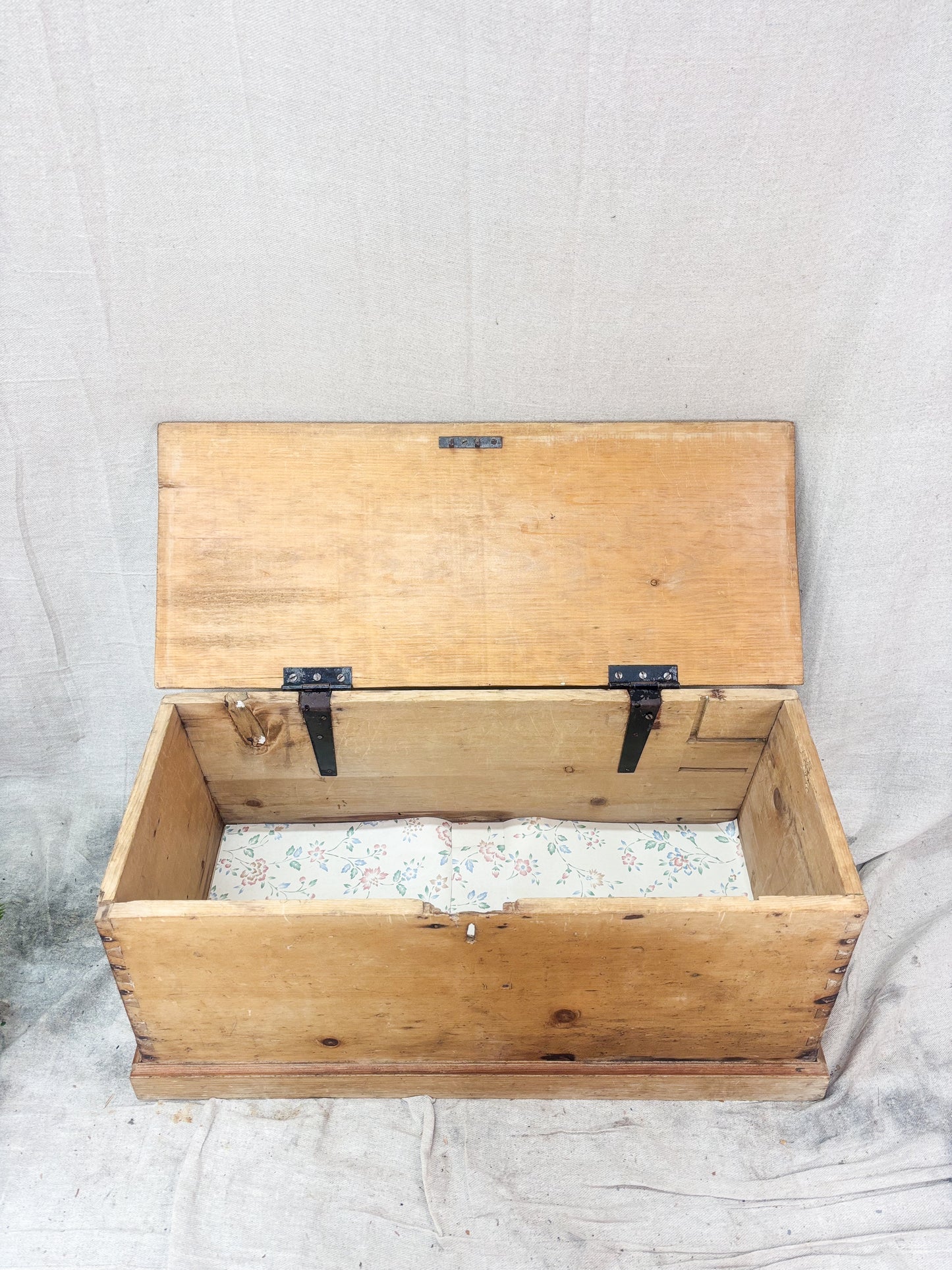 Wooden trunk with a hinged lid on a textured surface