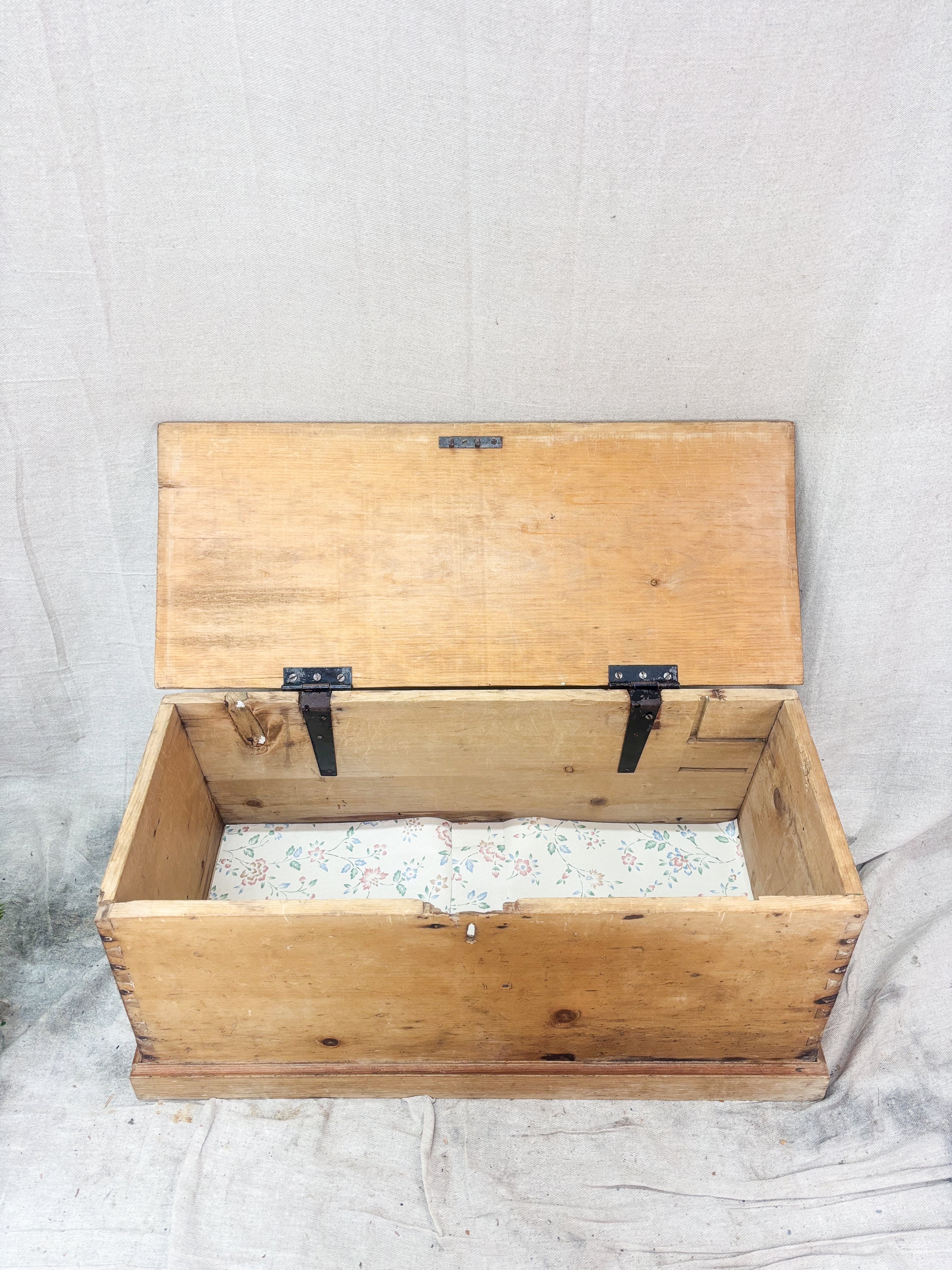 Wooden trunk with a hinged lid on a textured surface