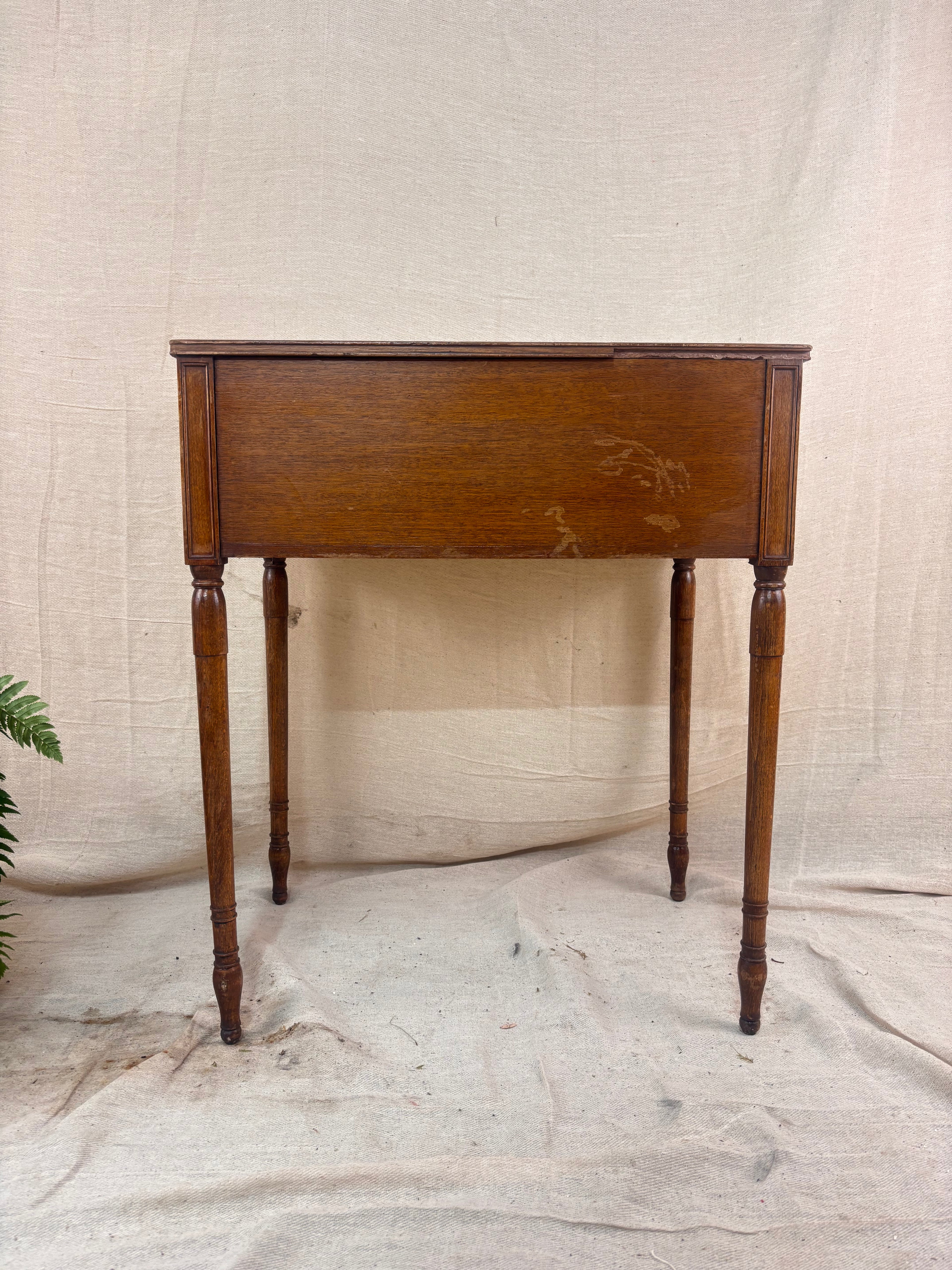 Regency-style mahogany side table with two drawers, slender ring-turned legs, and a neo-classical design, shown on a neutral background.