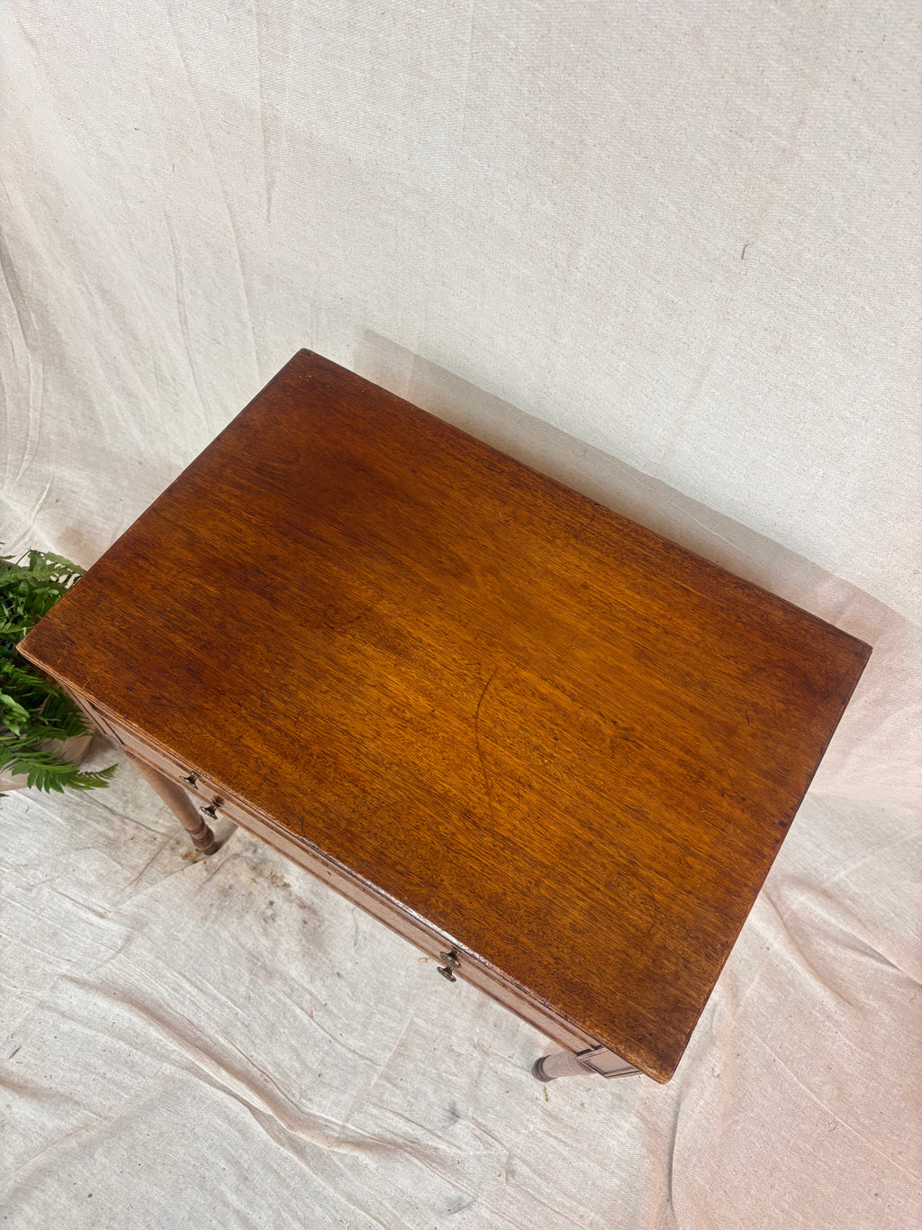 Top detail of Regency-style mahogany side table shown on a neutral background.
