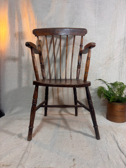 Wooden chair with a plant on a textured floor