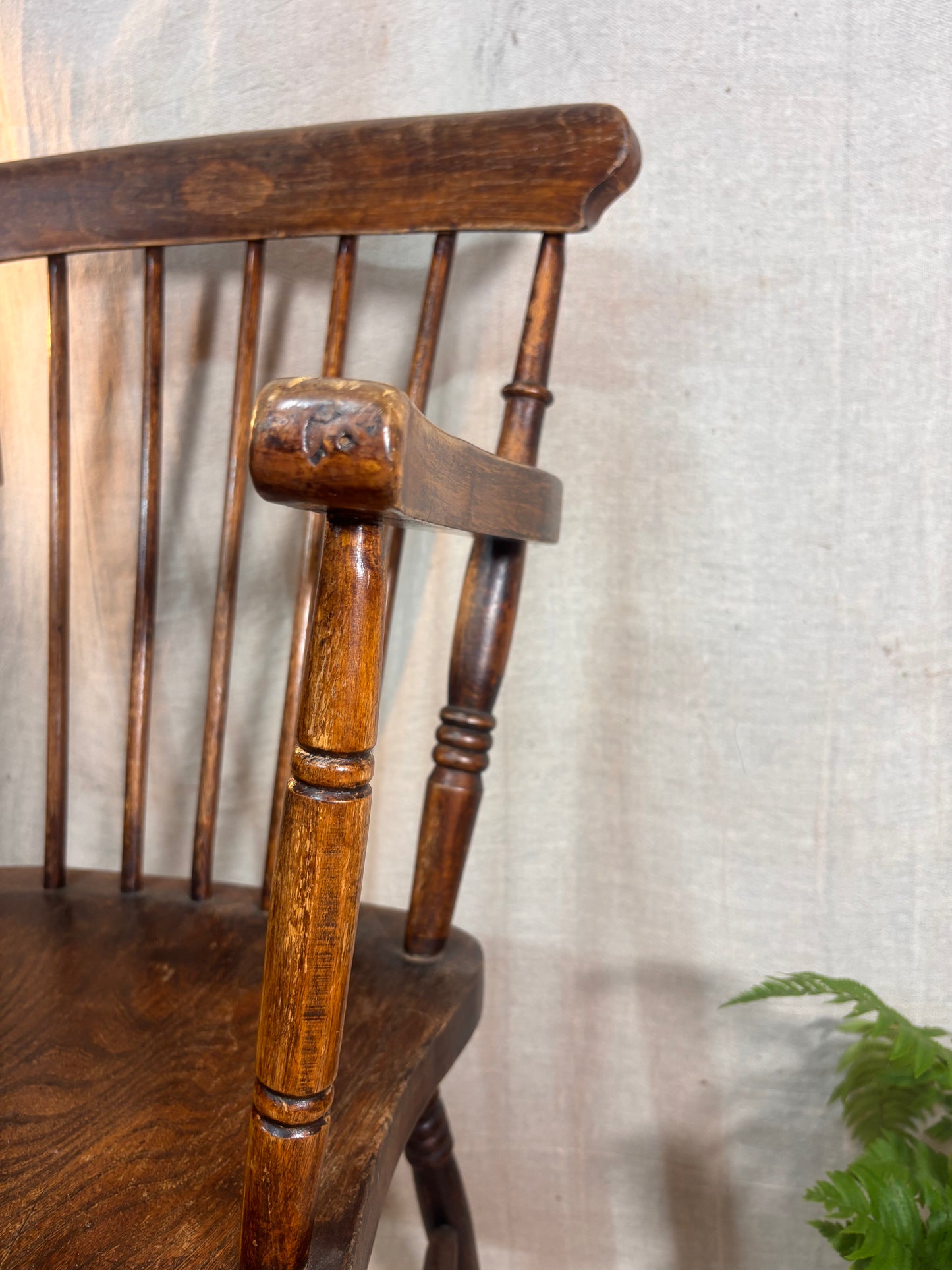 Close-up of a wooden chair with a textured wall background