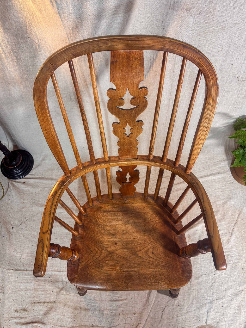 Wooden chair with intricate back design on a textured white background