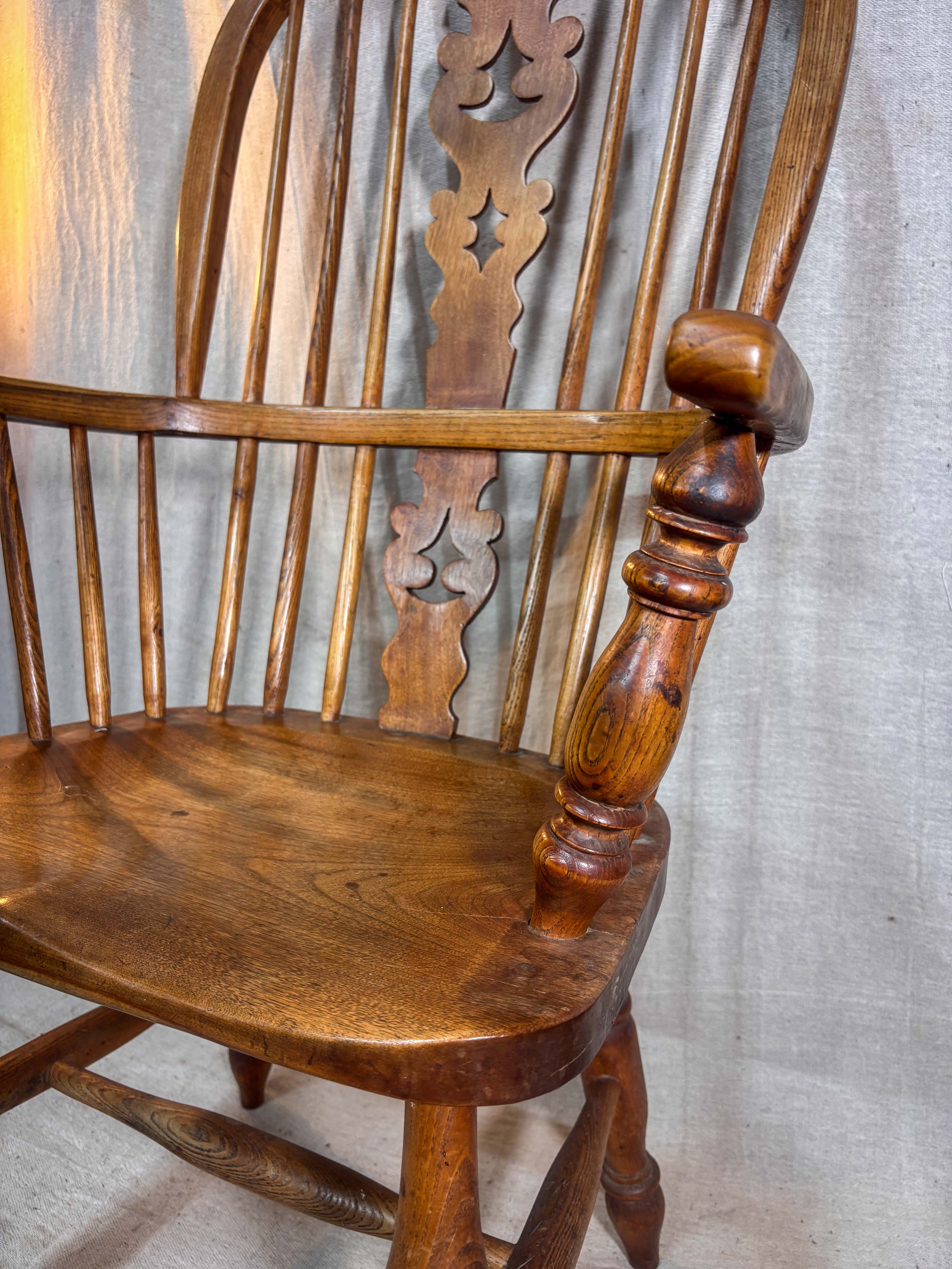 Wooden rocking chair with intricate carvings on a textured wall background