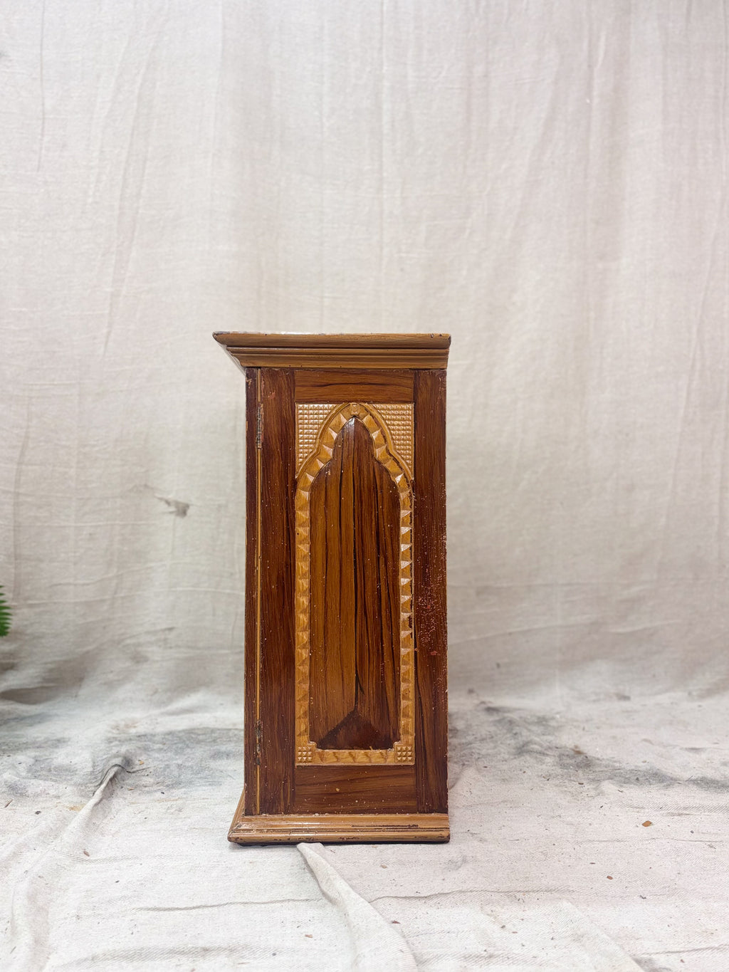 Wooden cabinet with decorative panel on a white background