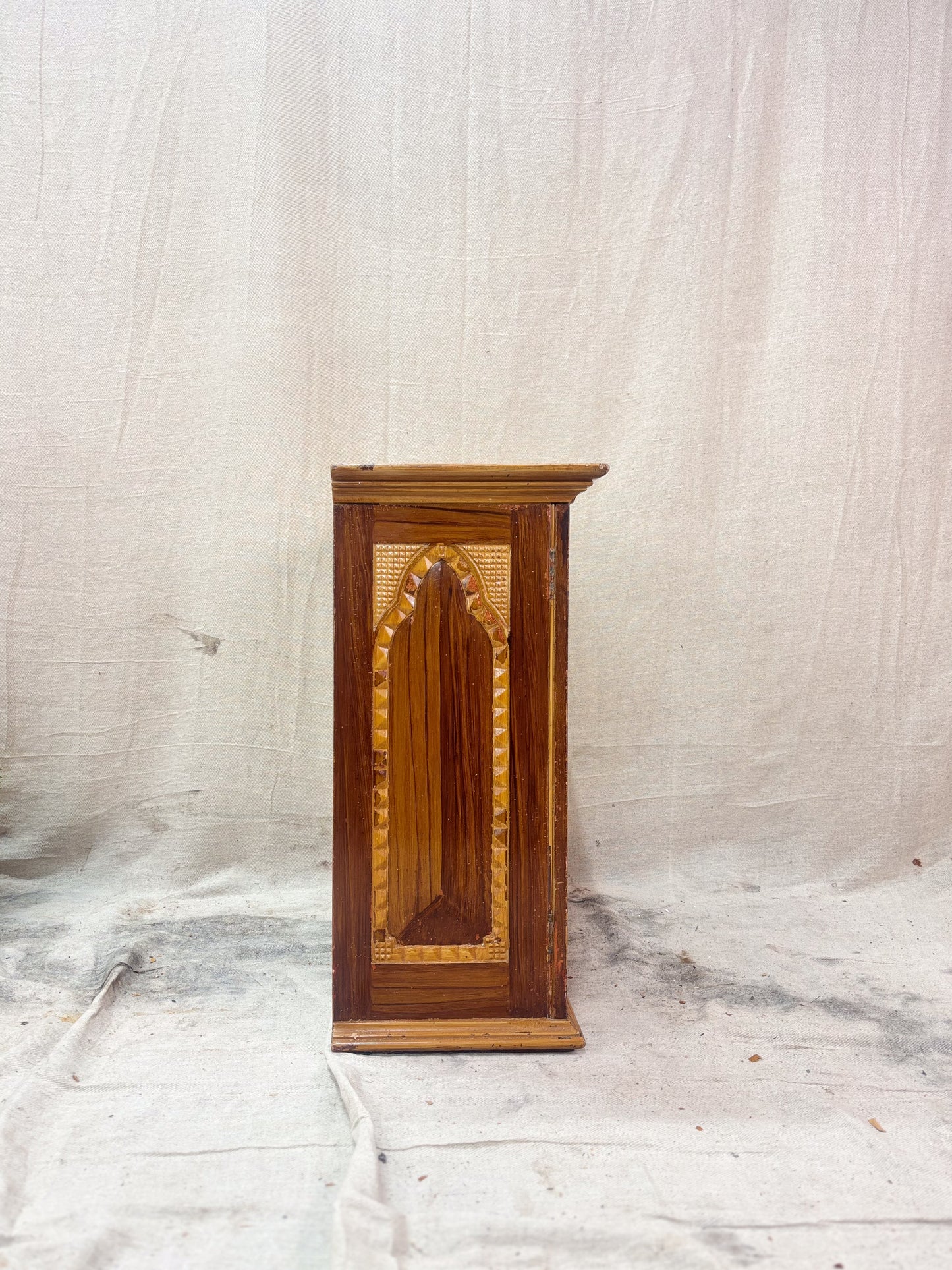 side of a wooden cabinet with carved details 