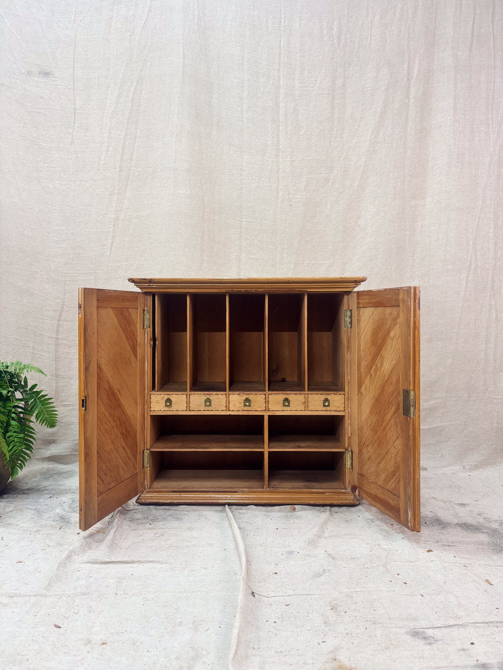 Wooden cabinet with open doors on a light background
