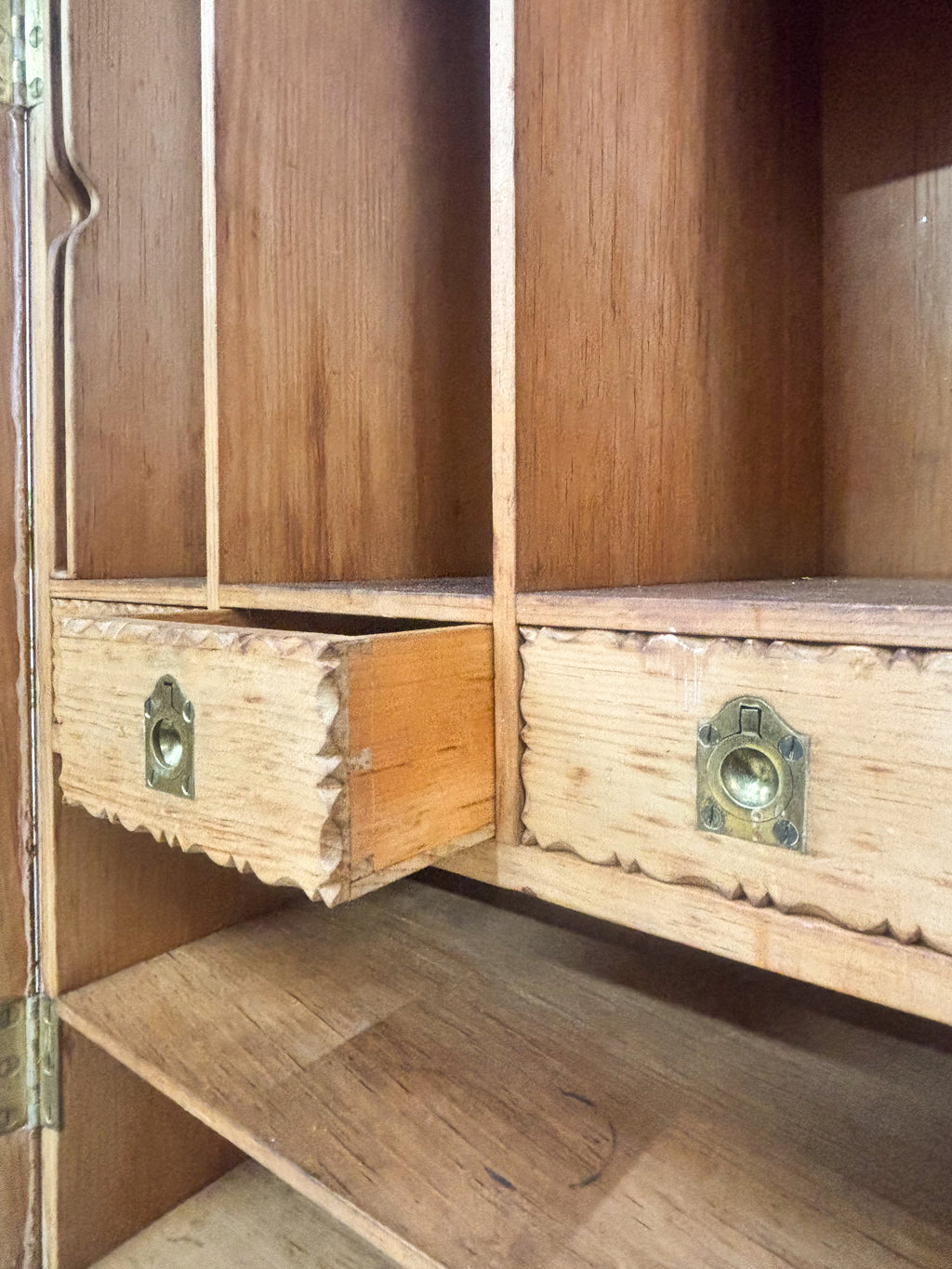 Wooden cabinet with open doors showing wear and tear.