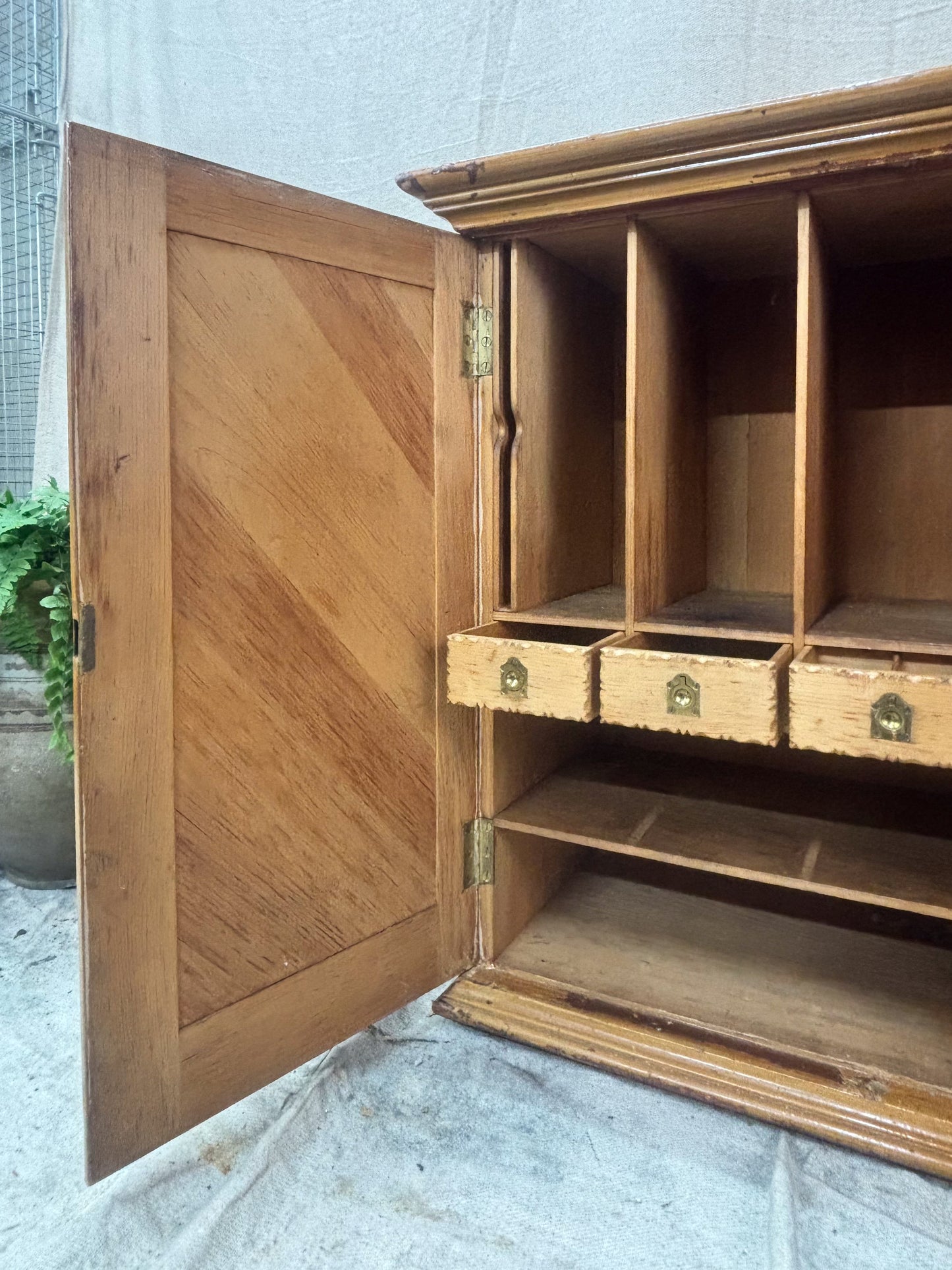 Wooden cabinet with open door on a concrete floor