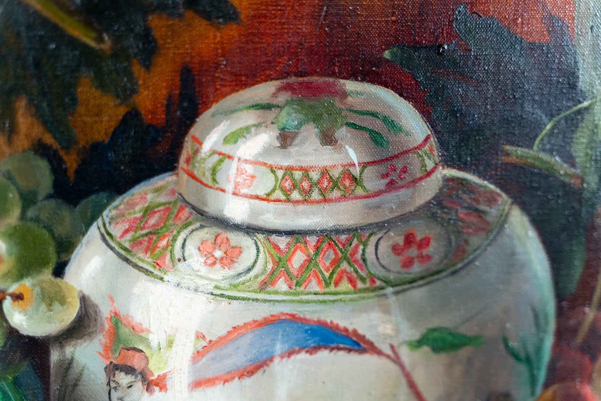 Close-up of a hand-painted ceramic lidded jar with intricate floral and geometric patterns in red, green, and blue on a white base, set against a dark, painterly background.