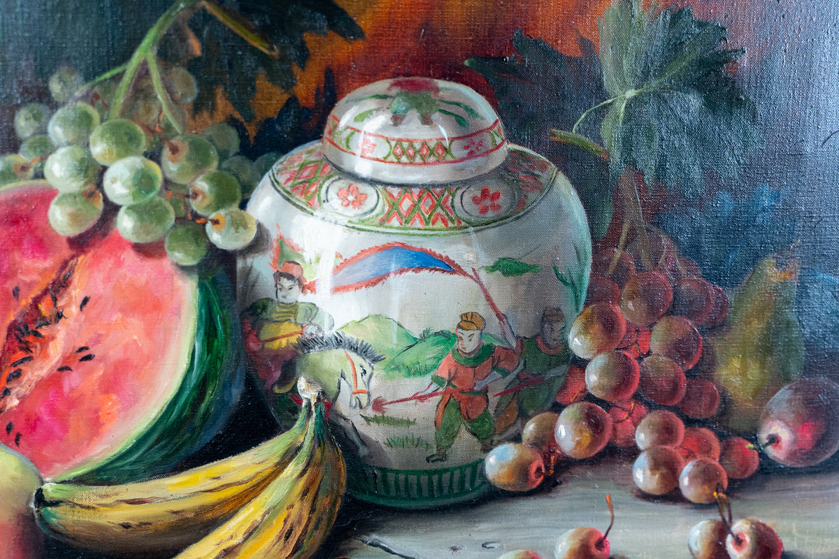 A still life painting featuring a decorative white ceramic jar with painted figures and patterns, surrounded by green grapes, red grapes, a sliced watermelon, bananas, and pears on a dark painted background.