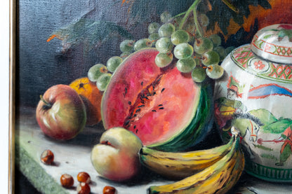 A still life oil painting depicting a sliced watermelon, green grapes, an apple, peaches, bananas, chestnuts, and a decorative ceramic jar against a dark background.