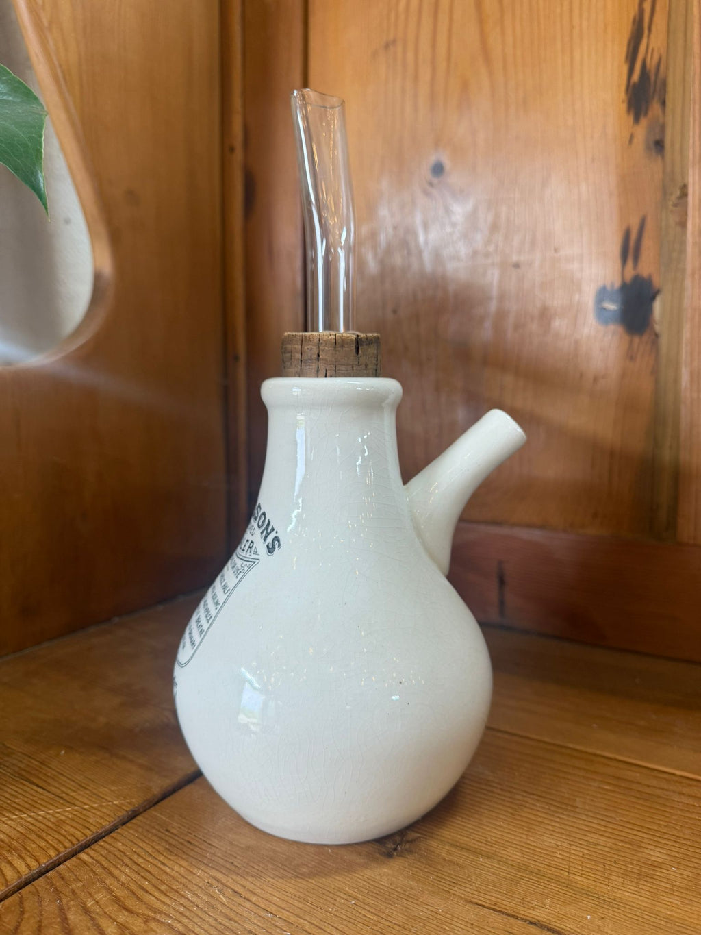 White ceramic inhaler with a clear spout on a wooden surface