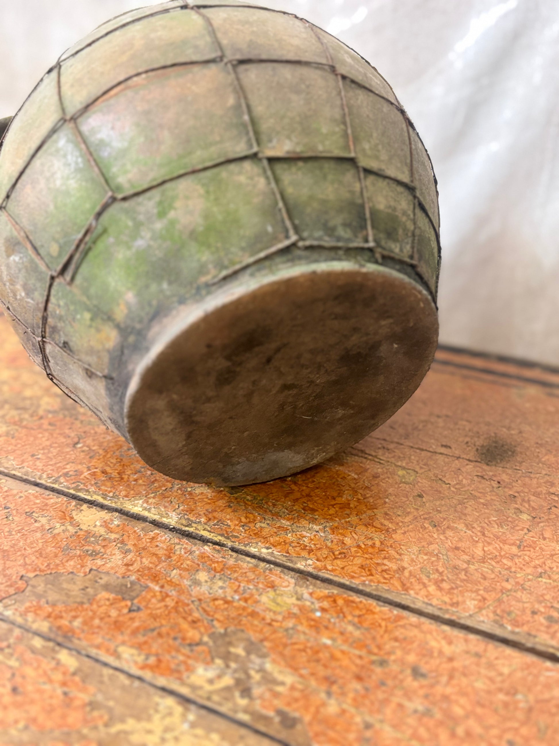 Vintage-style green stoneware container on a wooden surface