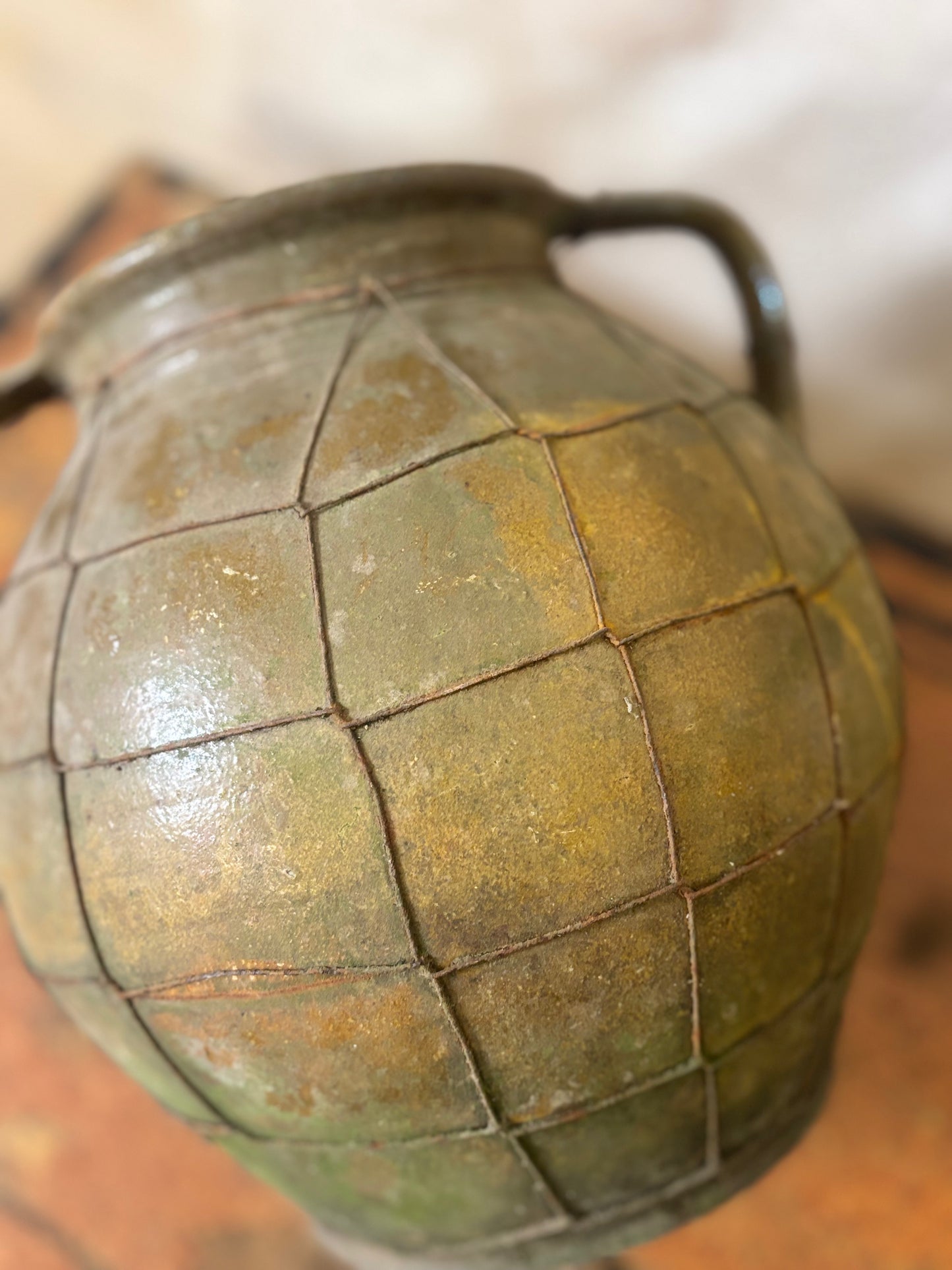 Close-up of a greenish-brown grenade on a wooden surface
