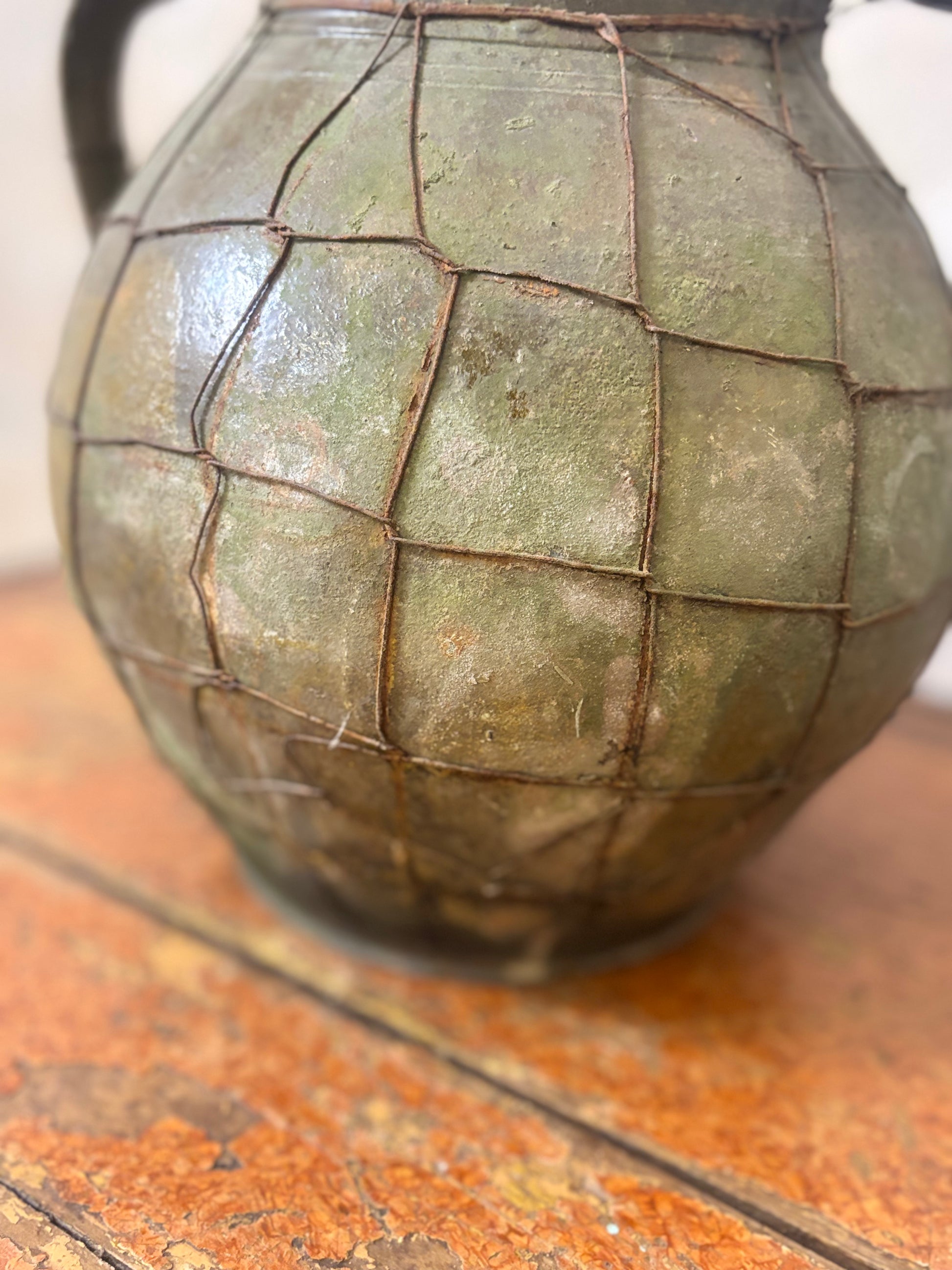 Vintage-style urn with a textured surface on a wooden surface