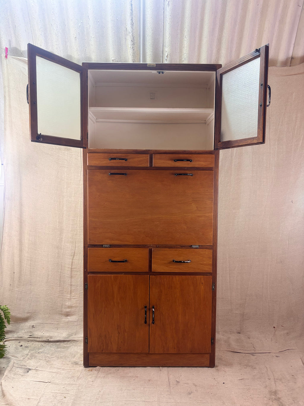 Wooden cabinet with open doors on a neutral background