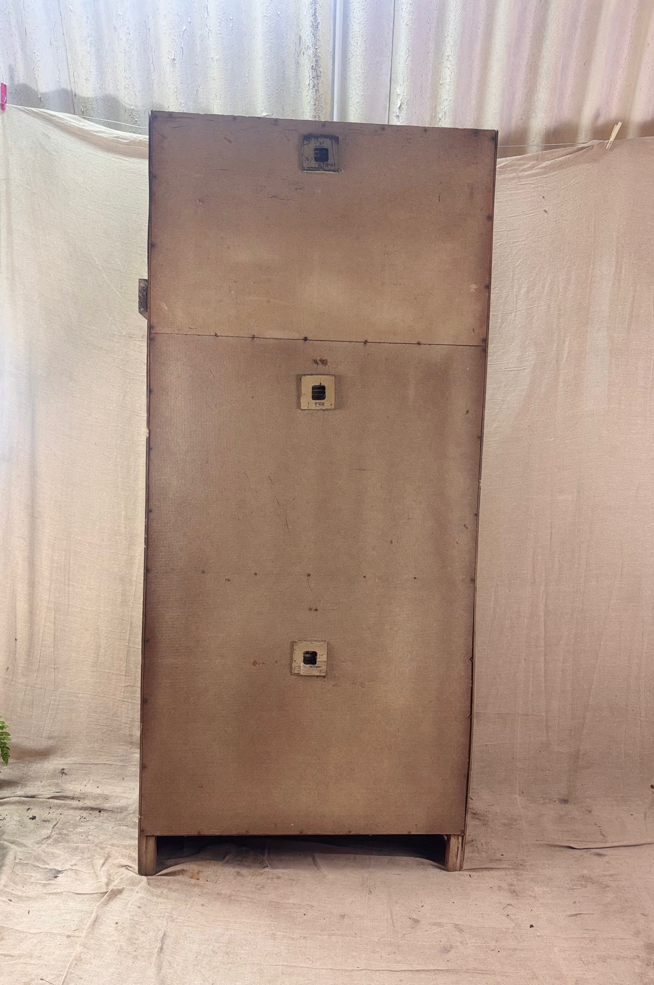 Rear of a Large cupboard with square holes on a light-colored floor and white curtain background