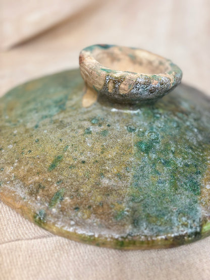 Green and brown ceramic plate on a beige surface
