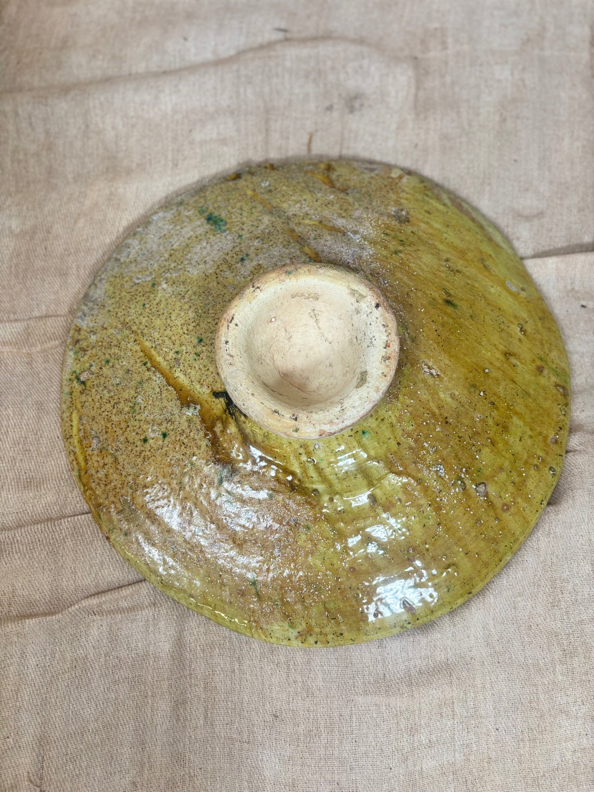 Ceramic plate with a textured surface on a beige fabric background