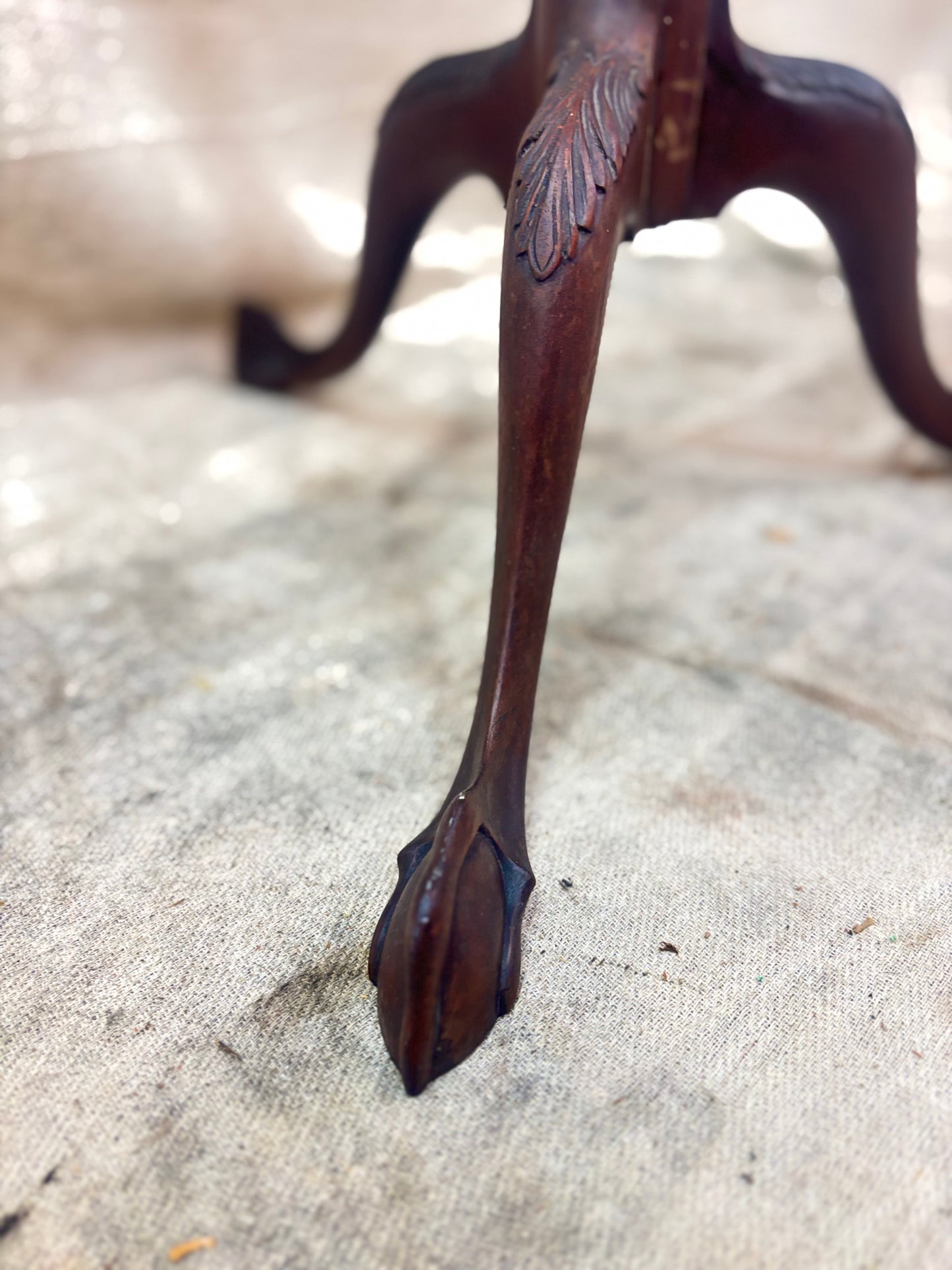 Close-up of a decorative wooden leg on a textured surface