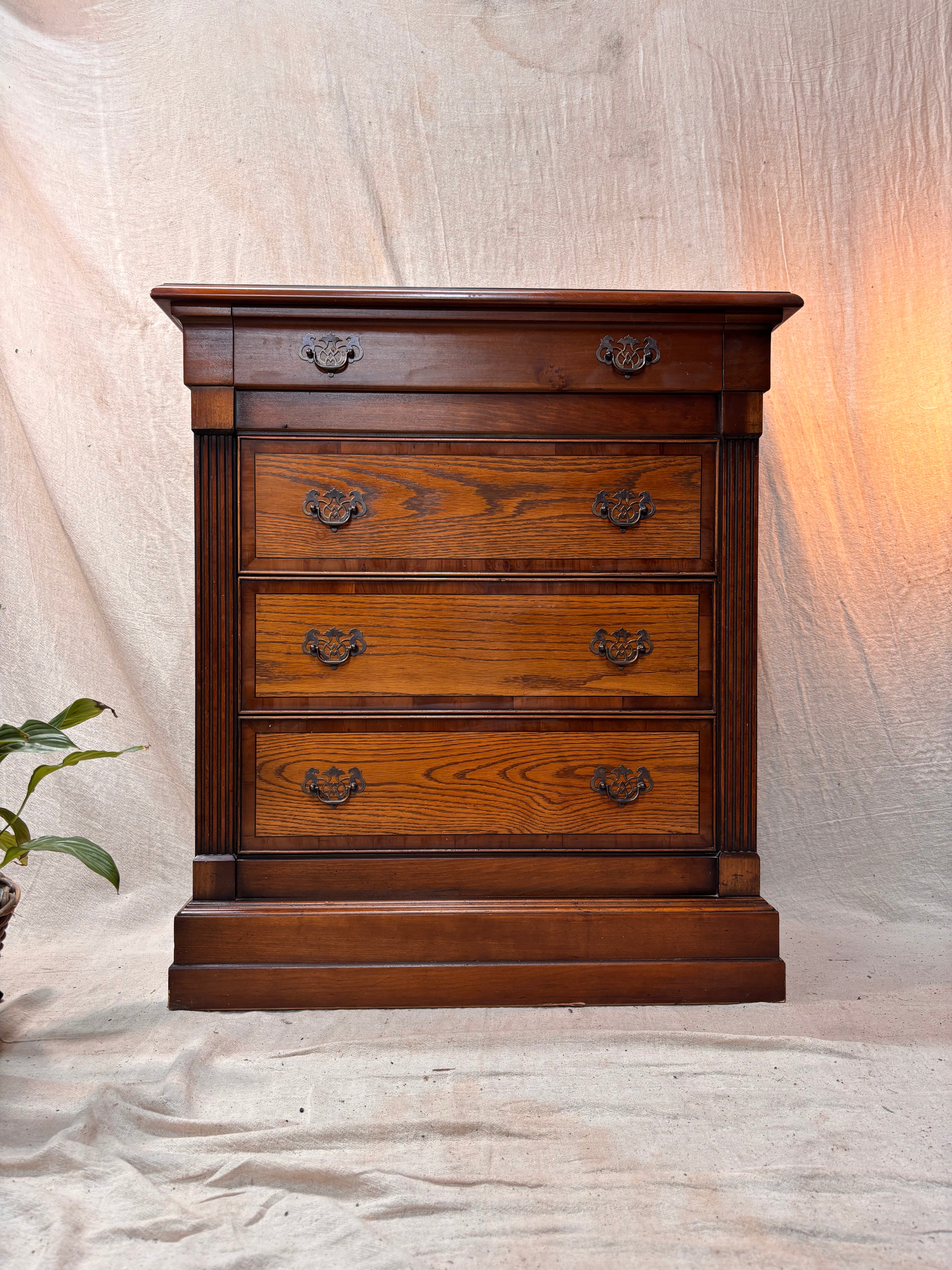 Wooden dresser with four drawers on a neutral background