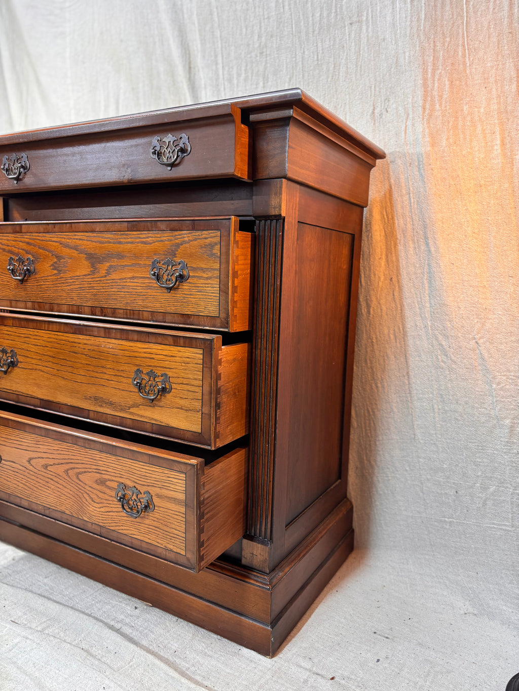 Wooden dresser with three drawers against a neutral background