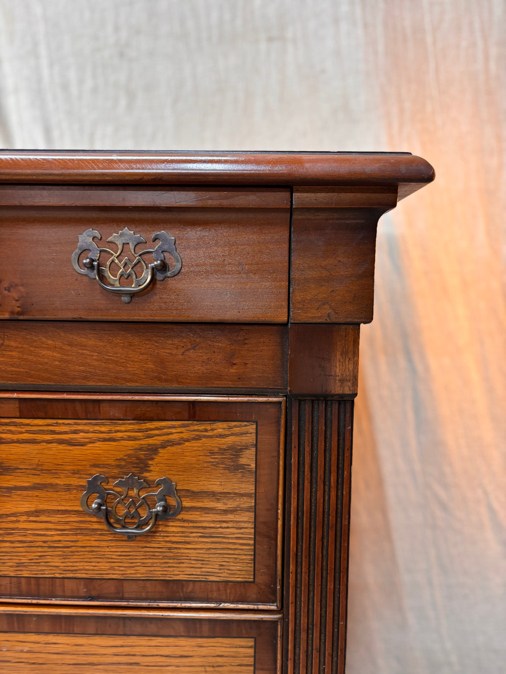 Wooden dresser with two drawers and decorative handles on a white background