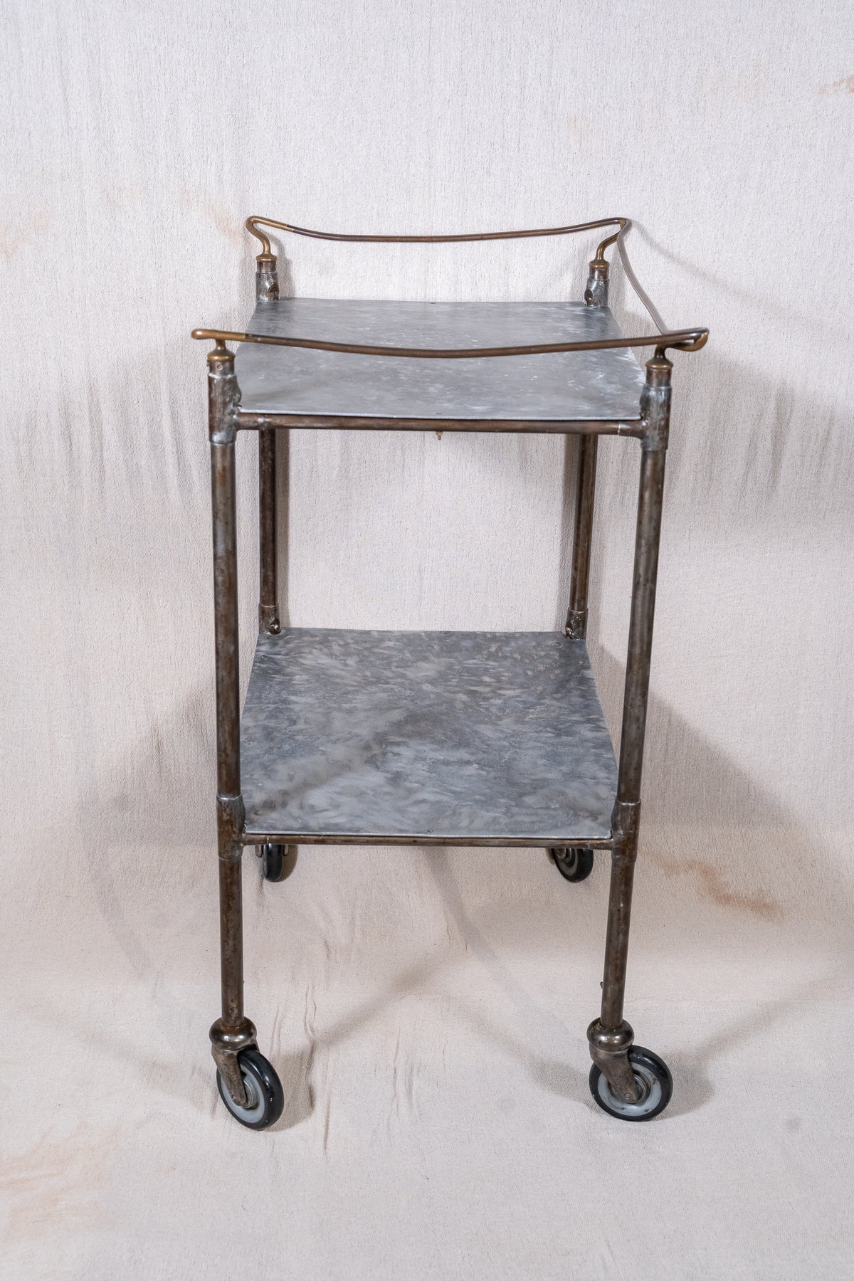 Vintage British medical trolley dating from the 1920s to 1940s, with tiered galvanised metal shelves, tubular steel frame and original swivel castors.
