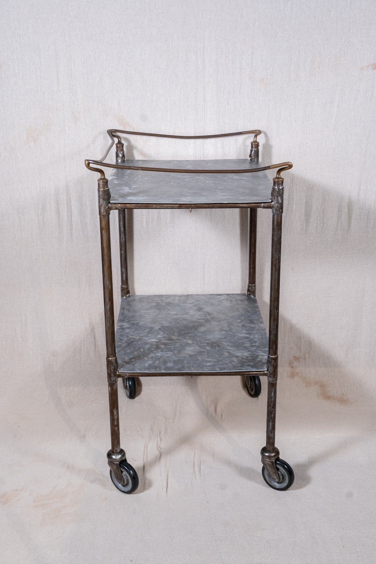 Vintage British medical trolley dating from the 1920s to 1940s, with tiered galvanised metal shelves, tubular steel frame and original swivel castors.