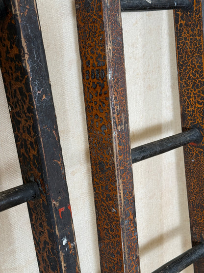 Pair of vintage wooden ladders with worn black paint