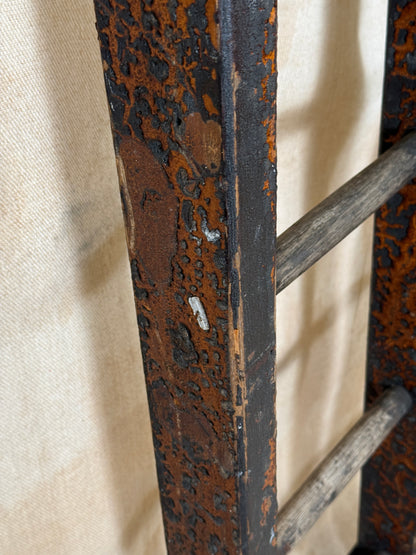 Pair of vintage wooden ladders with worn black paint
