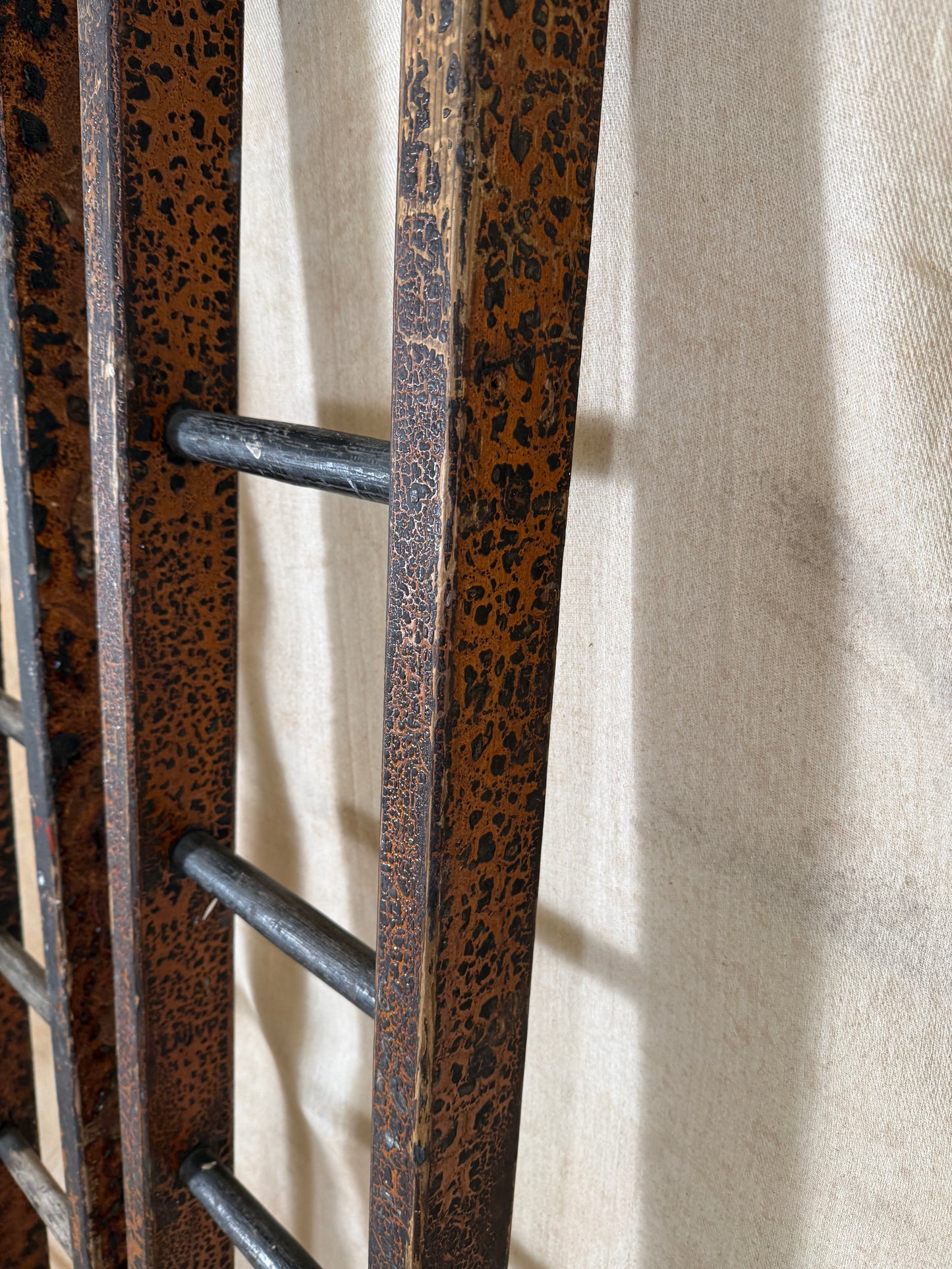 Pair of vintage wooden ladders with worn black paint