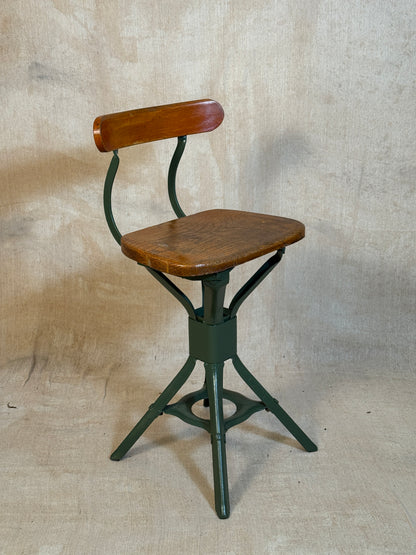 Vintage industrial machinist chair with green steel frame, wooden seat. 