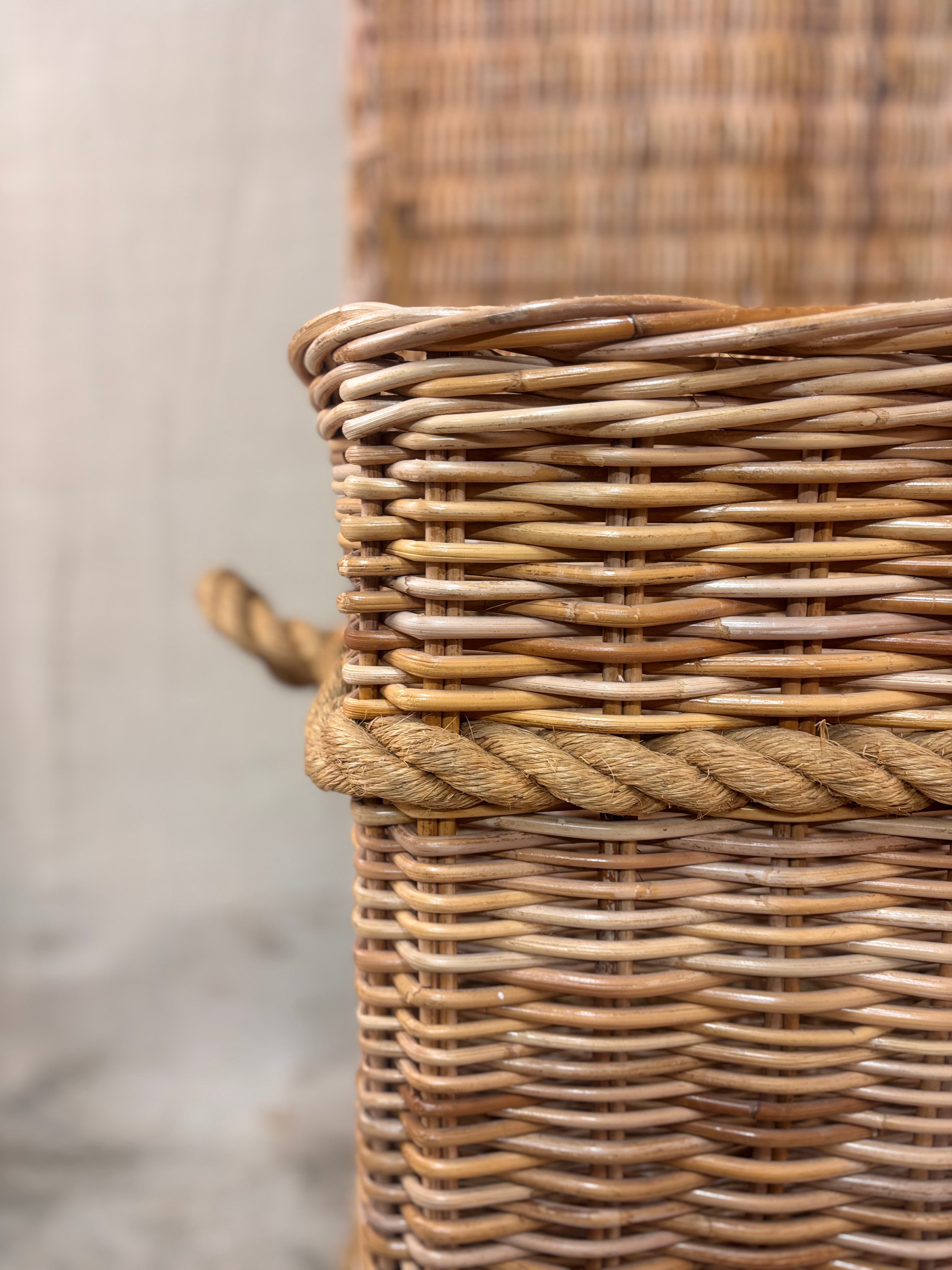 Large wicker storage basket with lid and rope banding, photographed against a neutral backdrop.